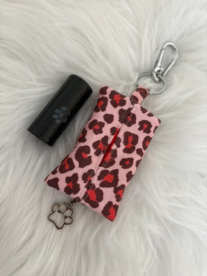 Distributeur de sacs à crottes fait main aux motifs léopard rouge et finitions argentées avec mousqueton et curseur patte de chat, vue de dos. Capacité : un rouleau de sacs à déjections canines, un rouleau de sacs offerts