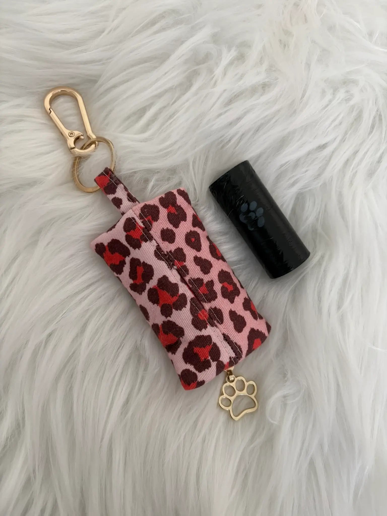 Distributeur de sacs à crottes fait main aux motifs léopard rouge et finitions dorées avec mousqueton et curseur patte de chat, vue de dos. Capacité : un rouleau de sacs à déjections canines, un rouleau de sacs offert
