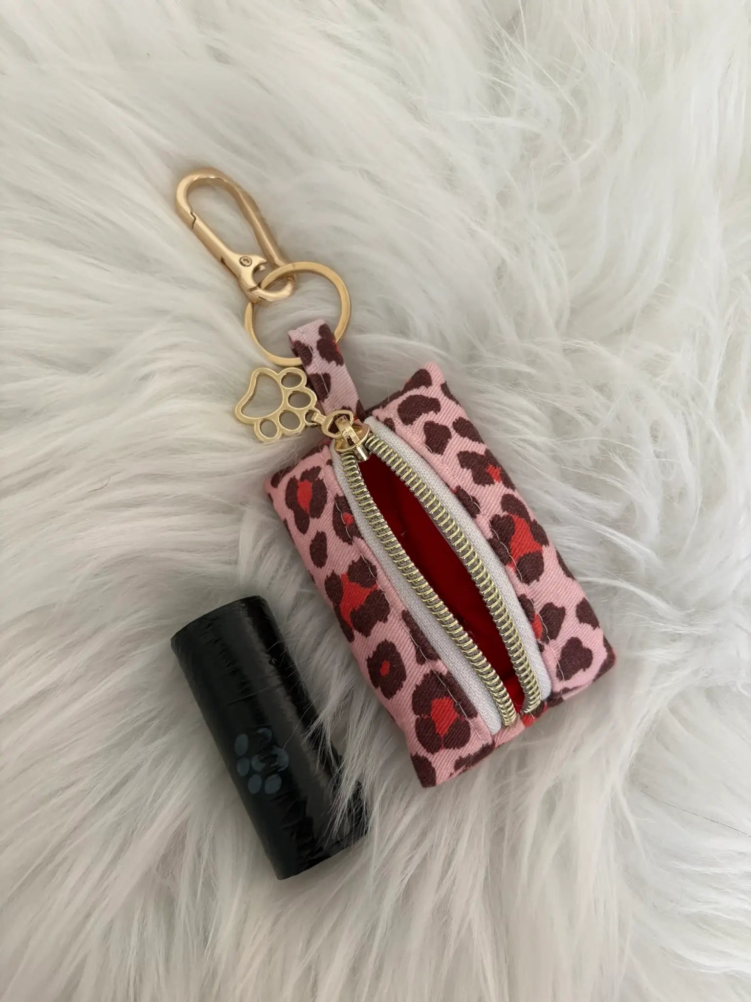 Distributeur de sacs à crottes fait main aux motifs léopard rouge et finitions dorées avec mousqueton et curseur patte de chat, vue doublure intérieure rouge. Capacité : un rouleau de sacs à déjections canines, un rouleau de sacs offert.