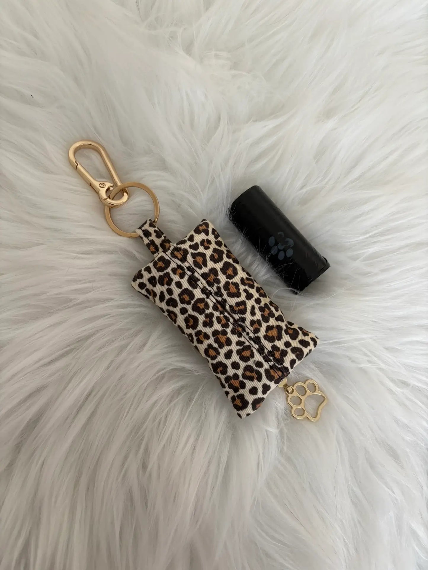 Distributeur de sacs à crottes fait main aux motifs léopard beige et finitions dorées avec mousqueton et curseur patte de chat, vue de dos. Capacité : un rouleau de sacs à déjections canines, un rouleau de sacs offert