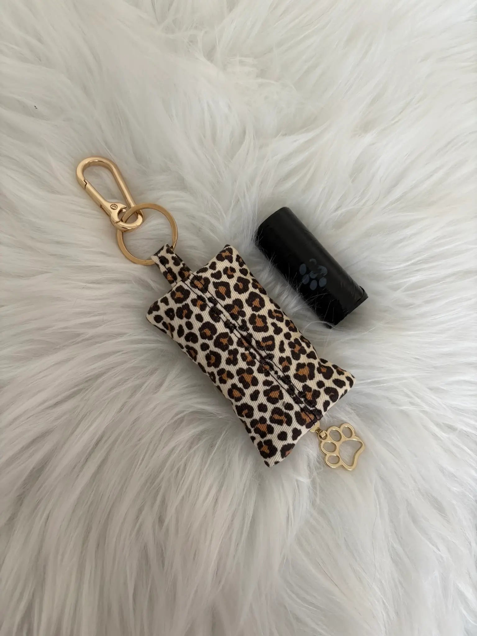 Distributeur de sacs à crottes fait main aux motifs léopard beige et finitions dorées avec mousqueton et curseur patte de chat, vue de dos. Capacité : un rouleau de sacs à déjections canines, un rouleau de sacs offert