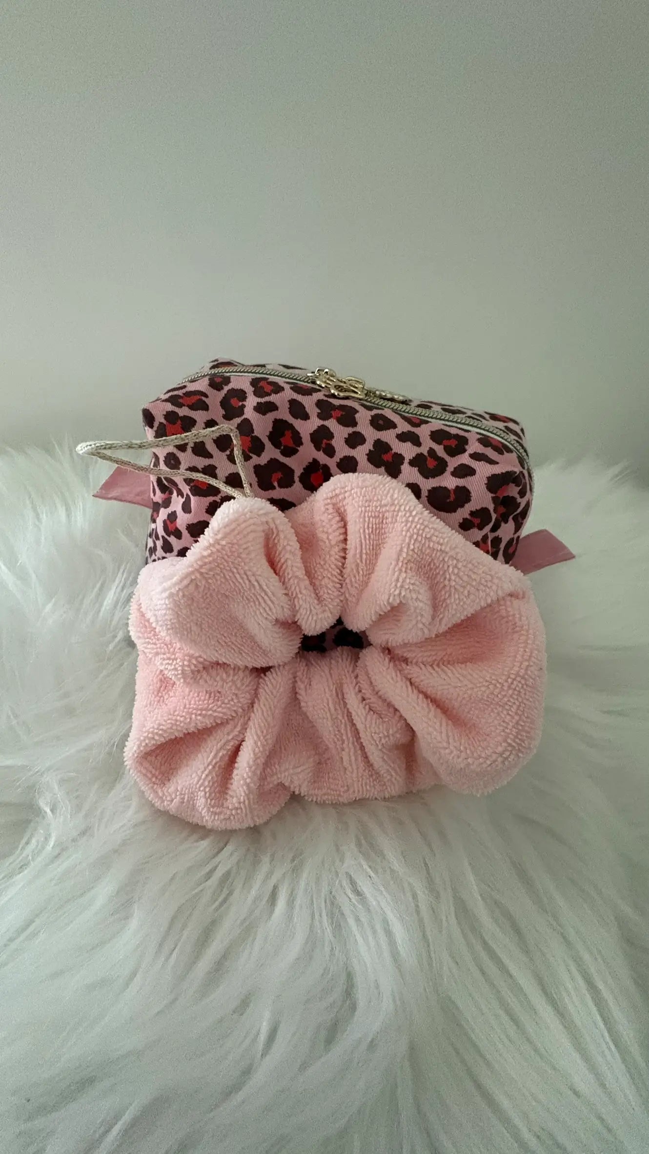 Fleur de douche artisanale rose avec cordon doré assortie à une trousse à maquillage aux motifs léopards.
