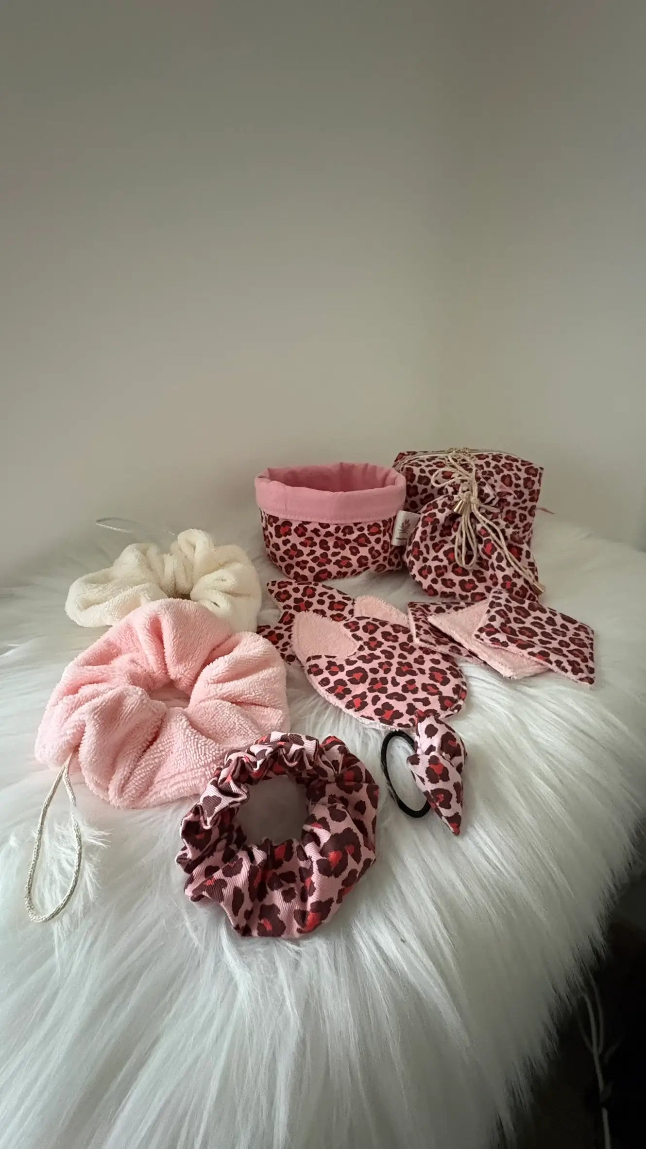 Ensemble coordonné fait main de panier, pochon, fleurs de douche, chouchous et lingettes aux motifs léopards roses et rouge pour visualisation de la collection
