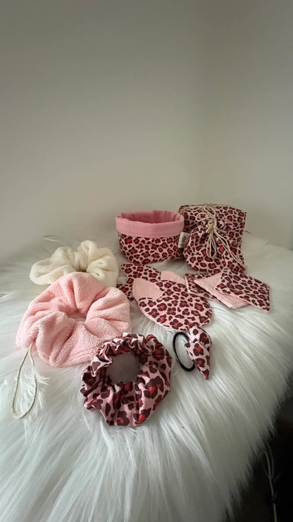 Ensemble coordonné fait main de panier, pochon, fleurs de douche, chouchous et lingettes aux motifs léopards roses et rouge pour visualisation de la collection