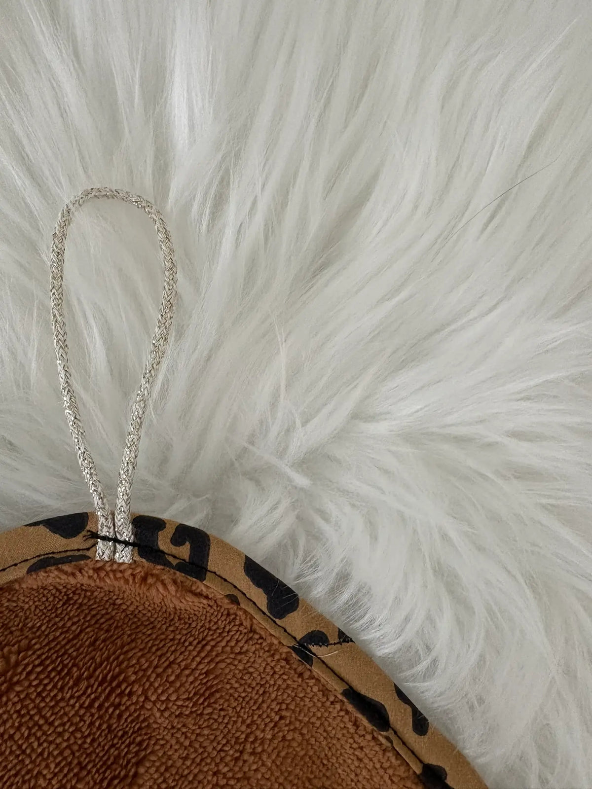 Zoom sur le cordon doré de l'essuie-pattounes pour chien et chat, pour pouvoir le suspendre facilement
