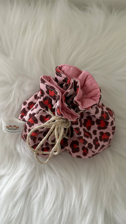 Pochon artisanal aux motifs léopards roses et rouges, cordon doré, vue de dessus