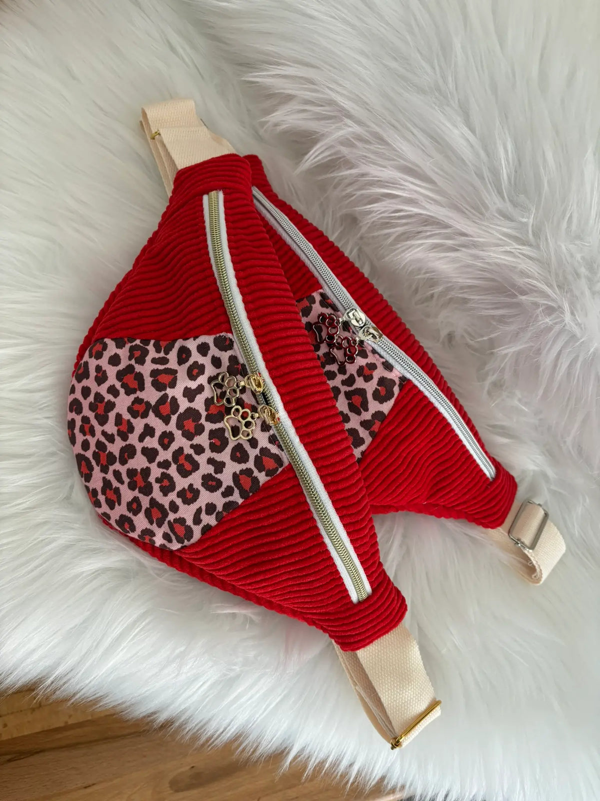 Deux versions de sacs banane en velours cotelé rouge et découpe léopard sur le devant, finitions au choix dorées ou argentées