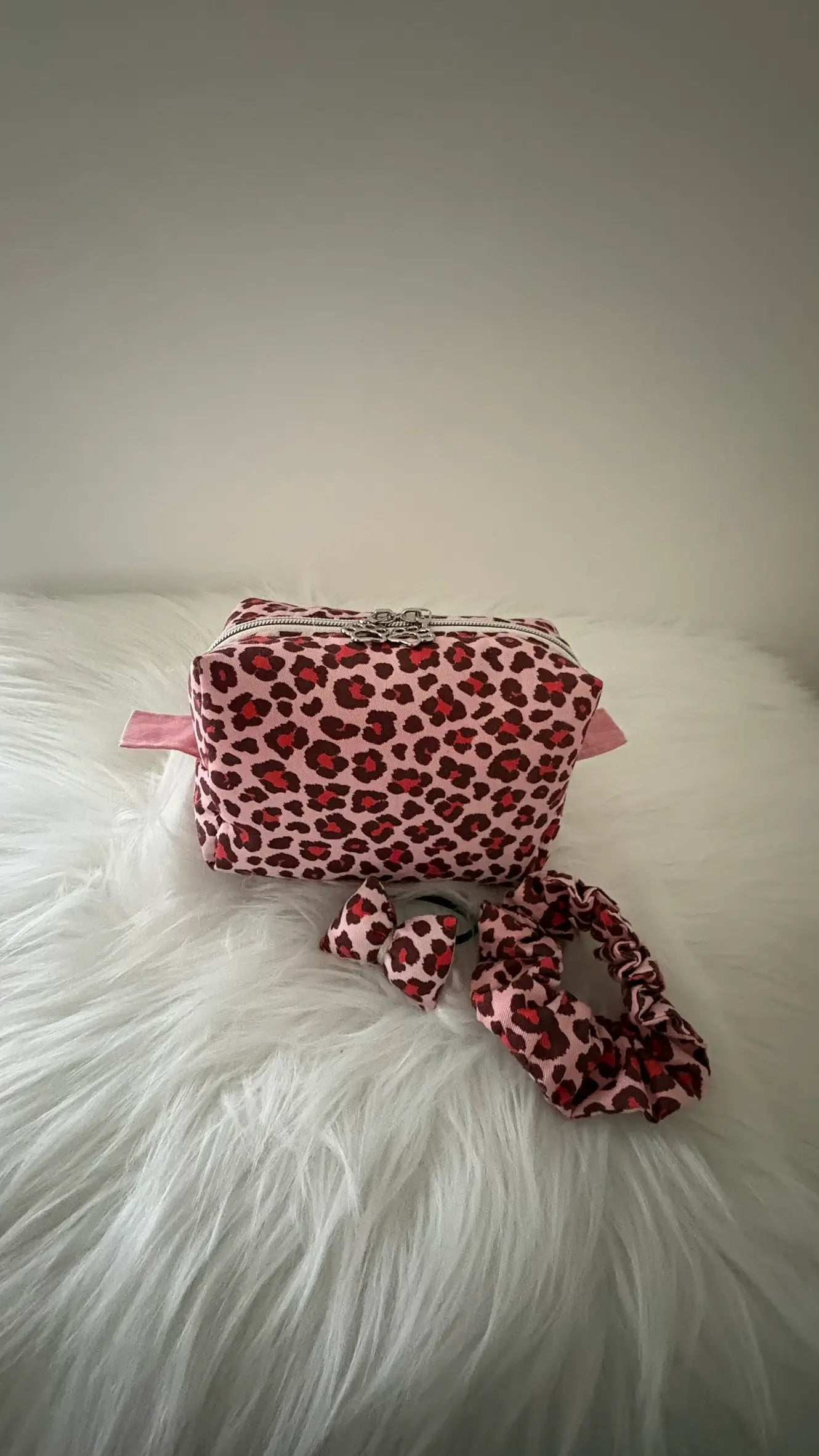 Trousse à maquillage artisanale aux motifs léopards roses et rouges, avec fermeture éclaire et deux curseurs pattes de chat argentés, avec chouchous assortis pour une idée d'ensemble coordonné