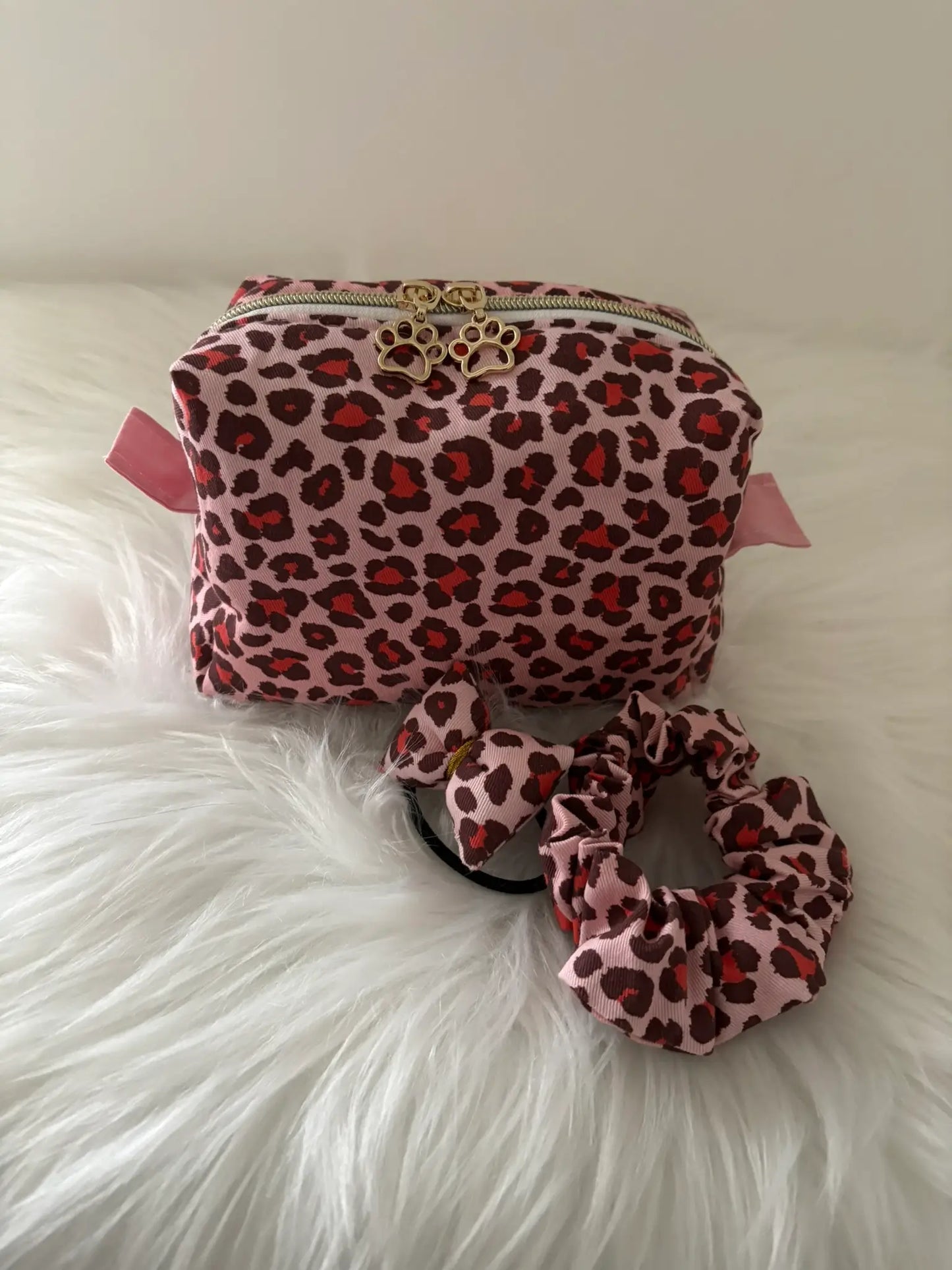 Trousse à maquillage artisanale aux motifs léopards roses et rouges, avec fermeture éclaire et deux curseurs pattes de chat dorés, avec chouchous assortis pour une idée d'ensemble coordonné