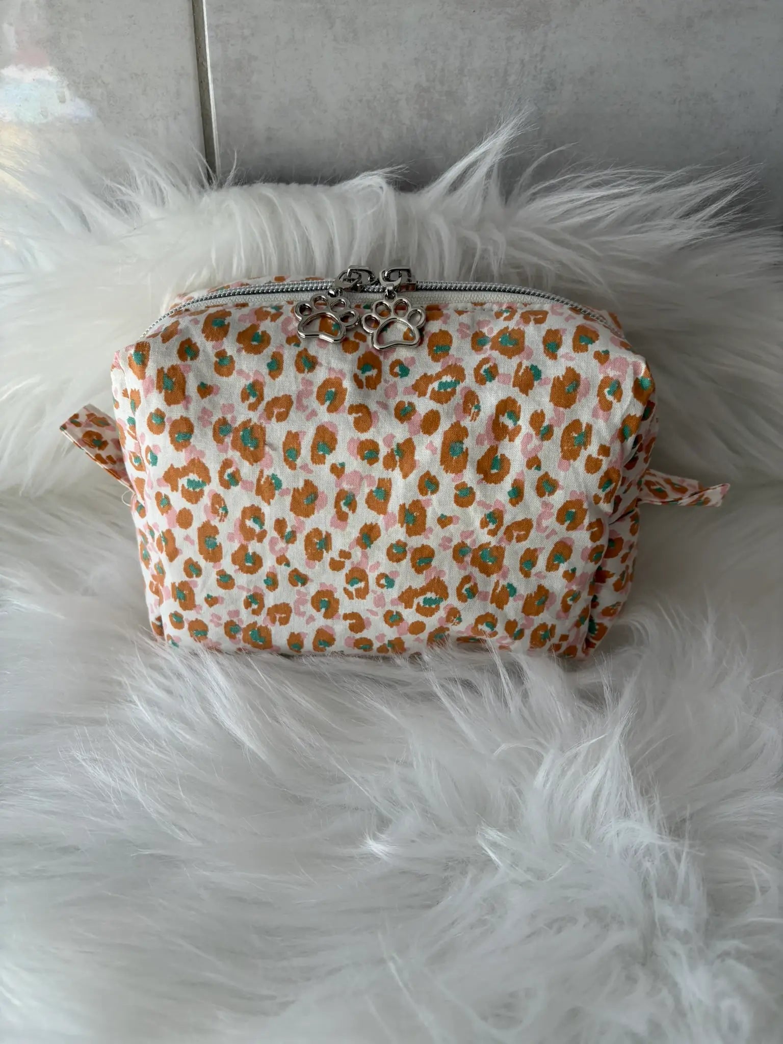 Trousse à maquillage faite main aux motifs léopards jaunes et marrons, avec fermeture éclair et ses deux curseurs argentés pattes de chat vue de face