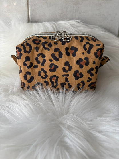 Trousse à maquillage artisanale à motifs léopard marron, avec fermeture éclair et deux curseurs pattes de chat argentés vue de face